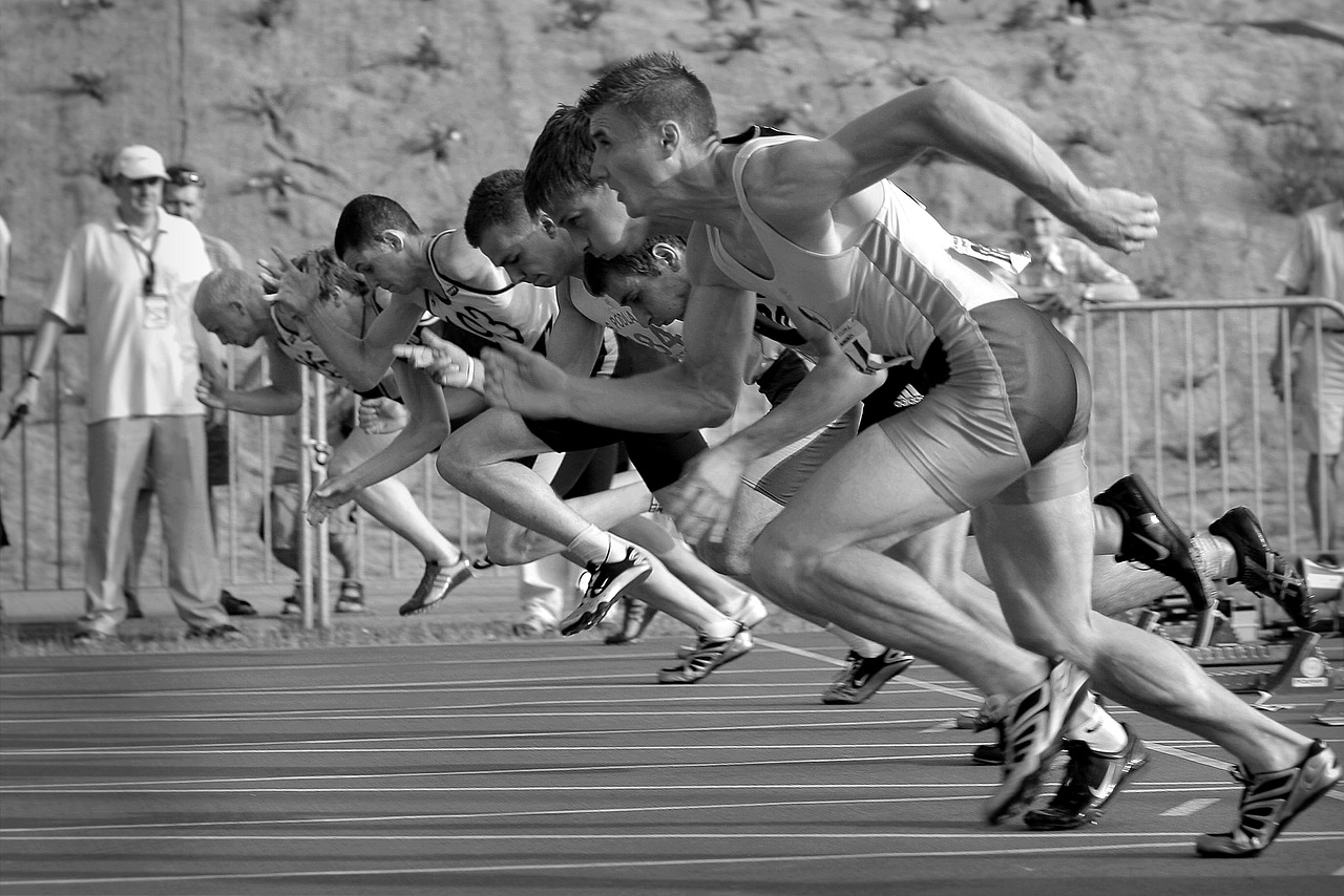 a line of sprinters exploding off their starting blocks as the race begins